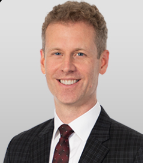 Image showing Marcus Graham of Clark Hill, with short brown hair, wearing a formal suit and tie, smiling at the camera.