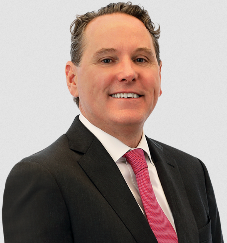 Image showing Matthew Collins of Brach Eichler, wearing a formal suit and tie, smiling at the camera.