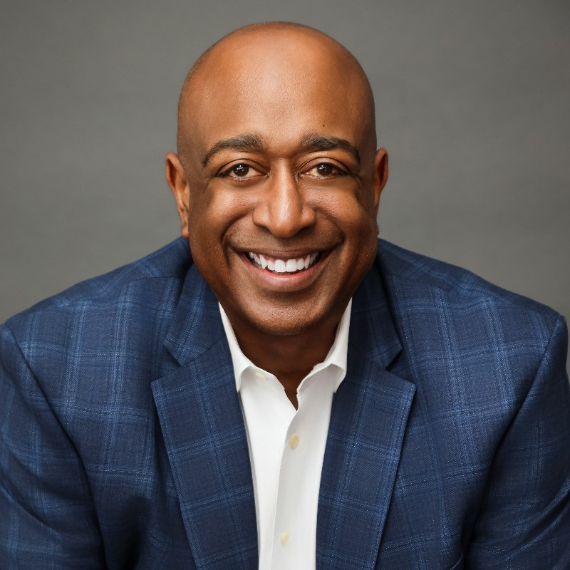 Image showing Donald Thompson of The Diversity Options, wearing a navy blue, checkered patterned formal suit, smiling towards the camera.